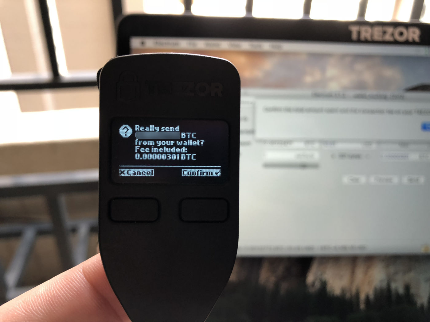 Confirming the transaction amount and mining fee on Trezor.